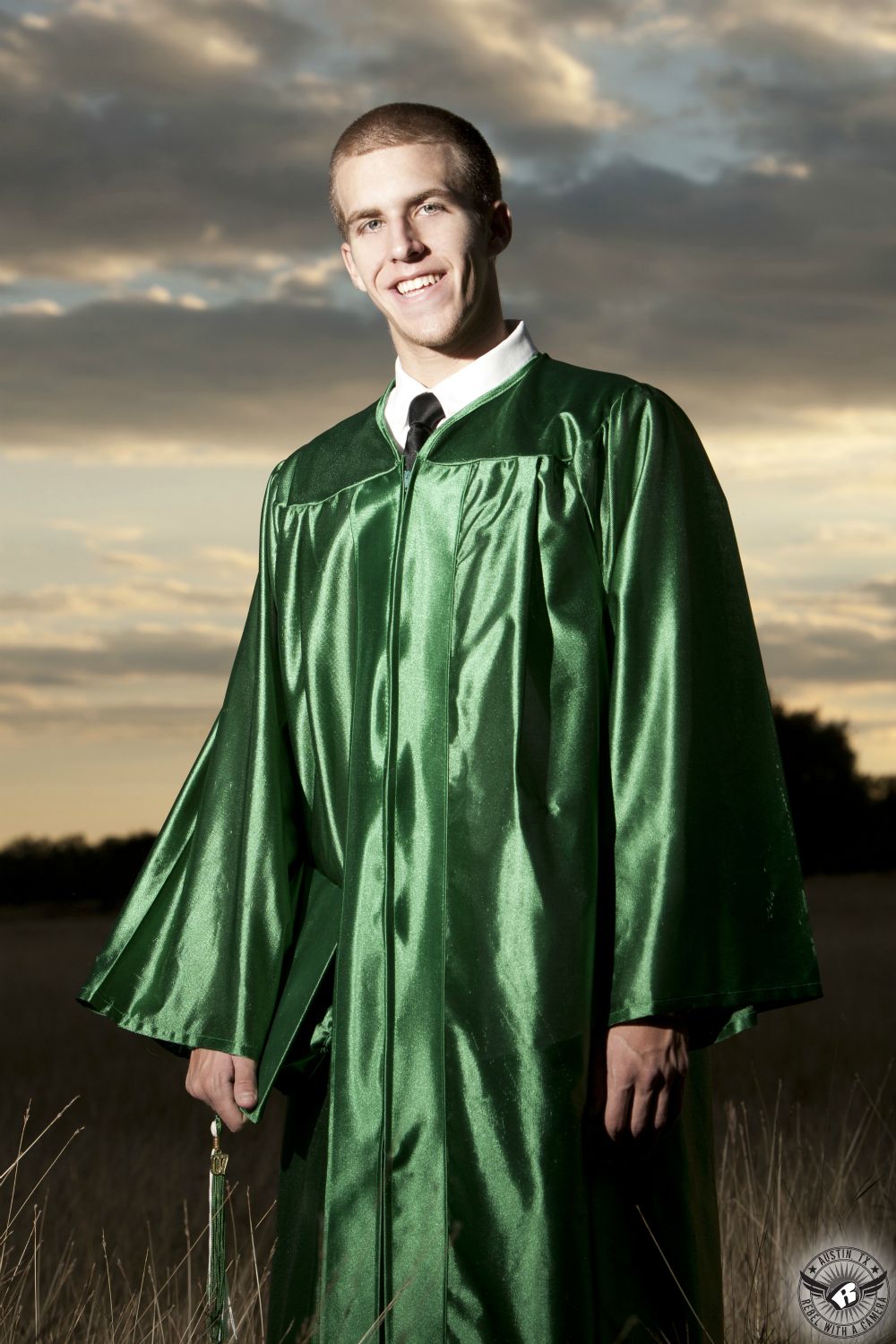 Rustic Texas high school graduation pictures of graduate in green graduation gown.
